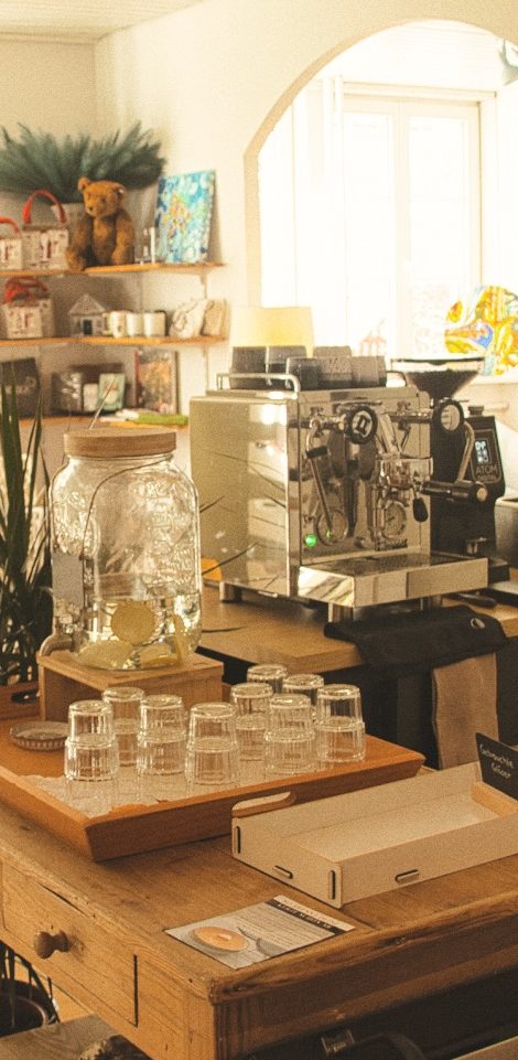 Eine einladende Kaffeeecke mit einer Espressomaschine und Gläsern auf einem Holztisch.